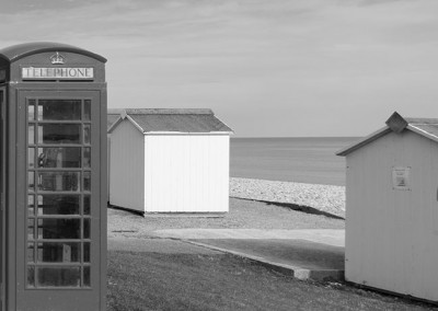 Old fashioned red telephone box and beach huts at Budleigh Salterton