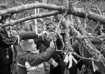 Mother and child tying a ribbon to the Wassail tree