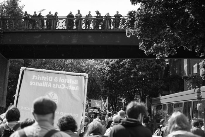 Anti-austerity march in Bristol approaches shopping centre bridge