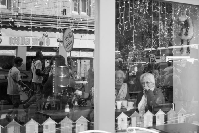 Reflection of the anti-austerity march in a Bristol window